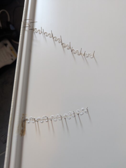 Reparerad badkarsfront sytt med tråd, redo för spackel och färg.