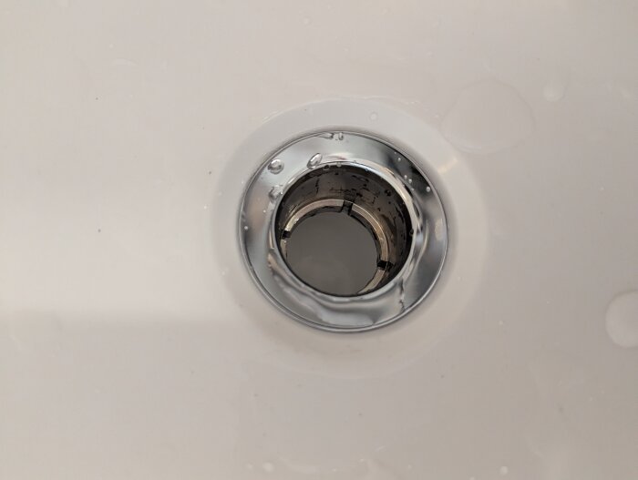 Dolt avlopp med sil i ett badkar, installerat för att minska behovet av rensning.