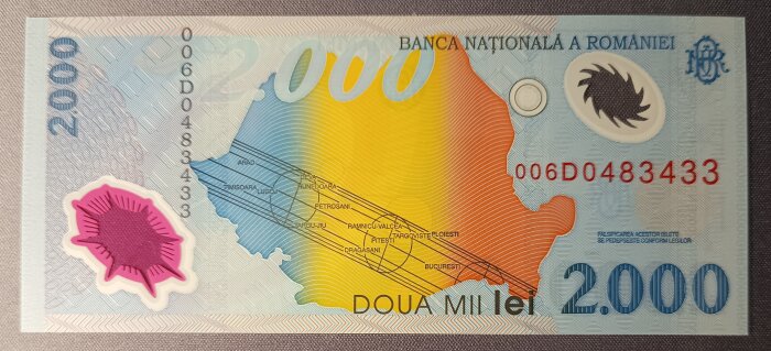 Färgglad 2000 lei polymersedel från Rumänien med solsystemmotiv och karta.