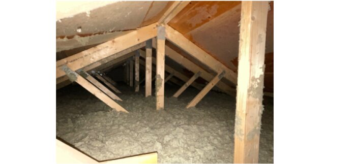 Vind med träbjälkar och lösull isolering.