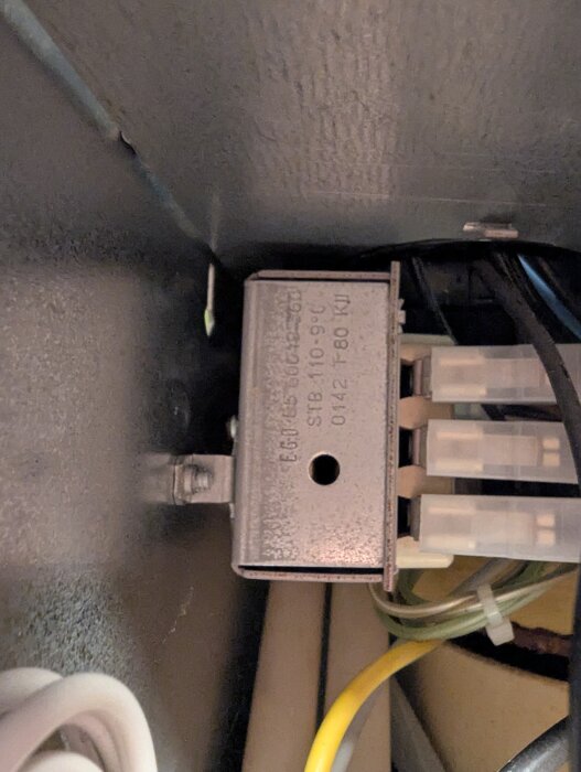 Termostat med överhettningsskydd och kopplingskablar i en panna, möjligtvis kopplade till problem med att pannan slår ifrån vid inställd temperatur.