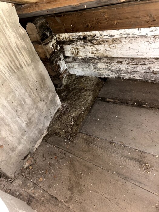 Bild på gammal trävägg och murstock med tecken på slitage och skador, vilket väcker frågor om husets strukturella hållbarhet.