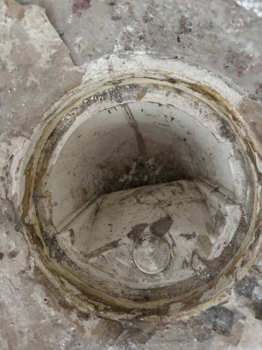 Golvbrunn med smutsig insats där användaren vill installera ett tätningslock.