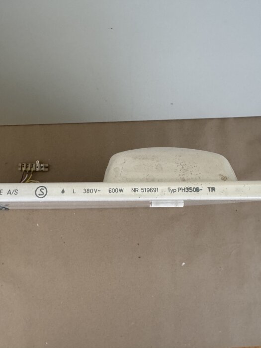 Bilden visar en elektrisk komponent märkt med 380V, 600W, typ PH3508-TR, installerad mot en vit vägg med några kablar synliga.