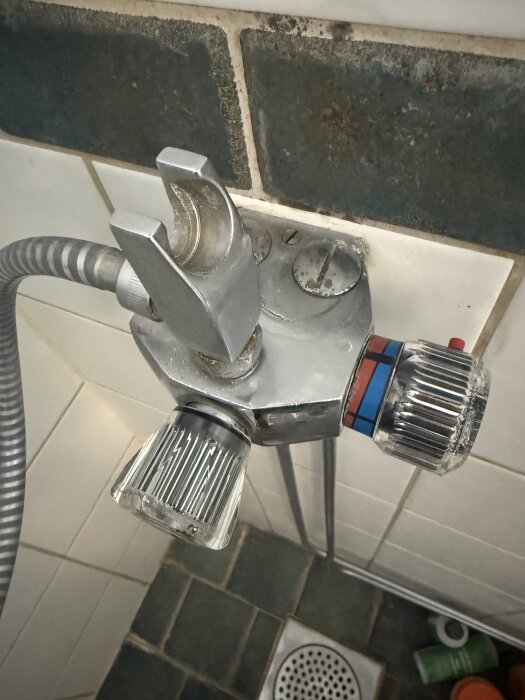 Äldre Mora termostatblandare i dusch med lösa vred och ventilkäglan delvis isatt; problem med återmontering av reglage och dropp.