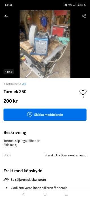 Slipmaskin Tormek 250 på ett bord i en verkstad, utan tillbehör, omgivet av verktyg och träbitar.