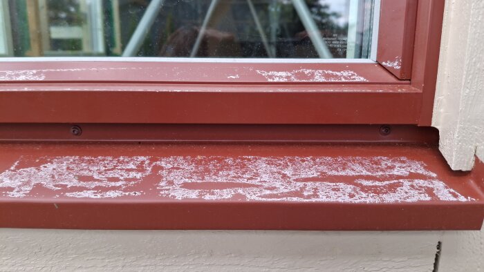 Röda fönsterbleck med vita limrester från maskeringstejp som suttit för länge och problem att ta bort utan att skada färg.