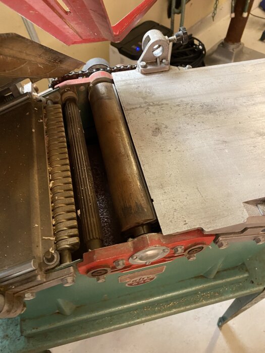 Hyvelmaskin med öppet skydd visar valsar och rem, del av ett renoveringsprojekt.