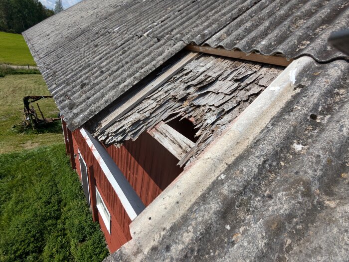 Trasig eternittakskiva på rött hus, exponerar skadat träbjälklag. Letar efter ersättningsplåt med samma sinuslängd, 130 mm.