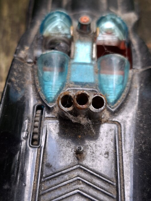 Närbild av granatkastarmynningar på en modell av Läderlappsbilen, med detaljerade blåa och svarta sektioner, delvis nedsmutsad.