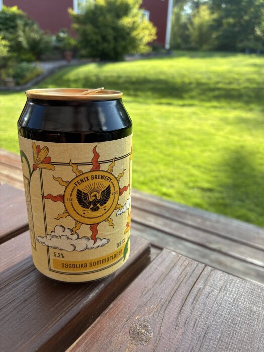 Ölburk från Fenix Brewery på en altan, med somrig grönska i bakgrunden.