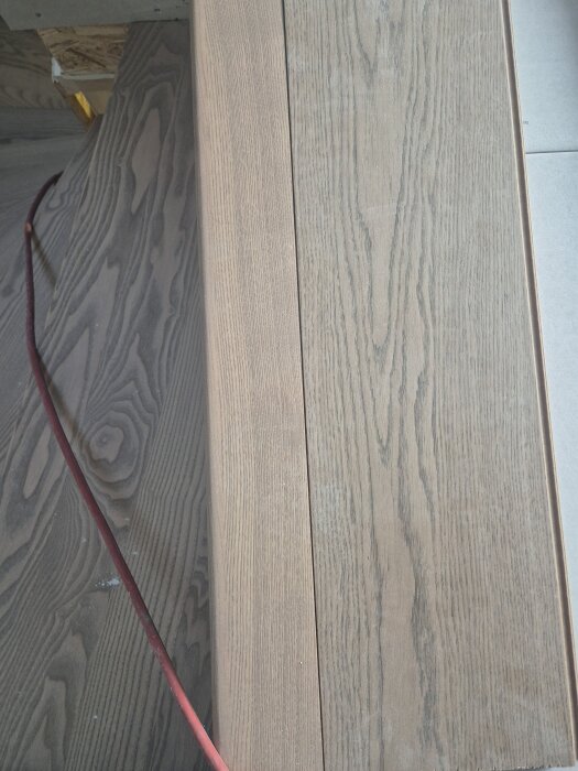 Trägolv intill trappa, huvudet av trappsteget synligt, diskussion om hur golvet bäst möter trappan med fokus på mjukfog eller flush installation utan list.