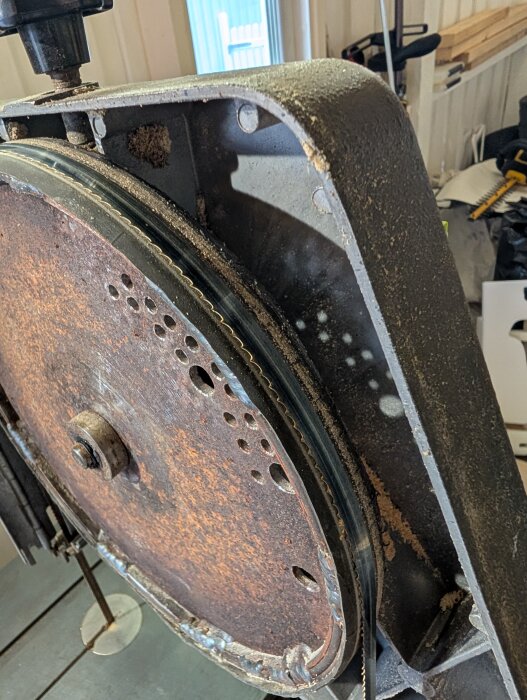 Inca bandsåg med hemmabyggt, rostigt övre hjul där gummi sticker ut 1-2 mm. Diskussion om justering av sågbladets position.