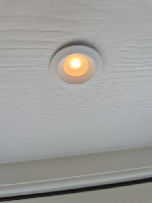 Spotlightlampa tänd i innertak, potentiellt felaktig installation i ett nytt hus.