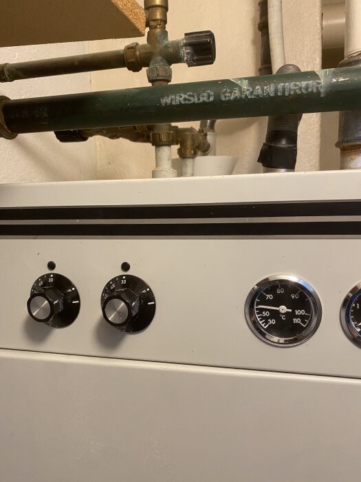 Kontrollpanel av TMV elpanna med två vred och två temperaturmätare. Pannan används för att justera vattenvärme.