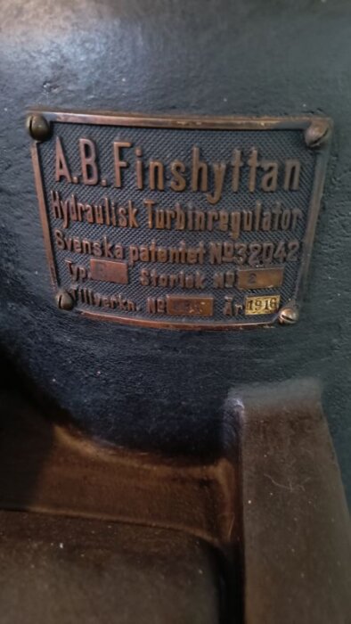 Skylt på en hydraulisk turbinregulator från A.B. Finshyttan, tillverkad 1916, sedd på ett kraftverk i Mellannorrland, byggt under första världskriget.