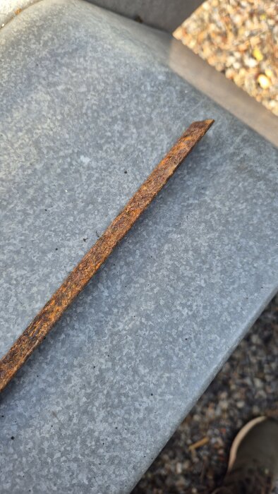 Rostigt stål på metallunderlag i utomhusmiljö.