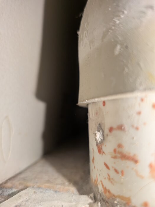 Närbild av en smutsig och sliten yta med en rördel, med fläckar och ett torrt utseende.