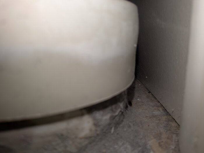 Smutsigt och torrt område bakom ett vitt rör.
