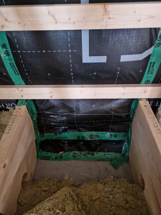 Väggkonstruktion där isolering har tagits bort och ersatts med diffusionsöppen duk och tejp.