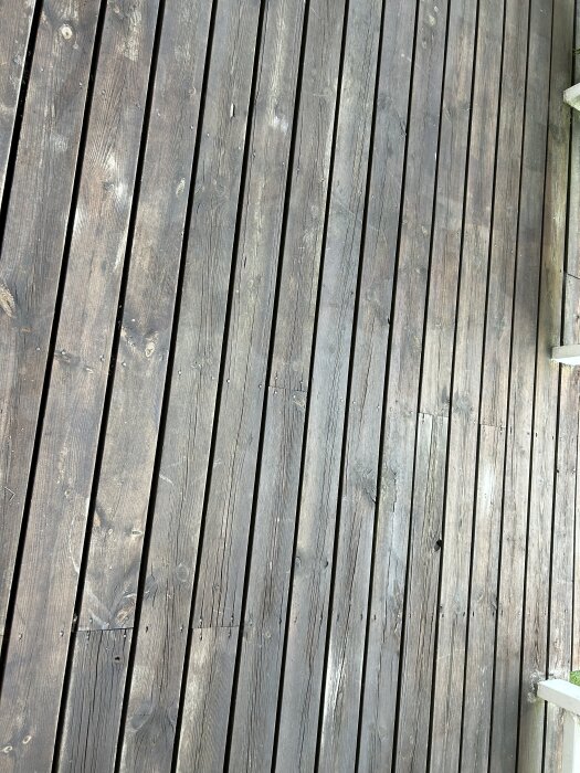 Träaltan med åldrad yta och en del flagnande färg; brädorna ser stabila ut utan tydliga sprickor eller skador.