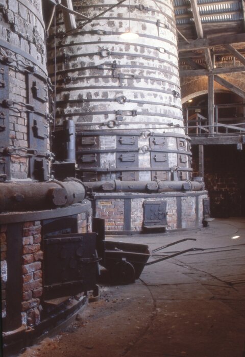 Rostugn vid Iggesunds järnverksmuseum, byggd av tegel och metall med flera dörrar och ventiler, ger en historisk inblick i ståltillverkning.