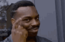 Man pekar mot sitt huvud med ett leende, som om han visar att han tänker smart.