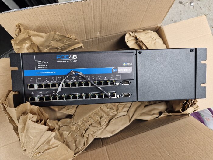 Ny Swanson 24-portars Poeswitch i kartong, märkt med PoE48, leverantörsinformation och tekniska specifikationer synliga på enheten.