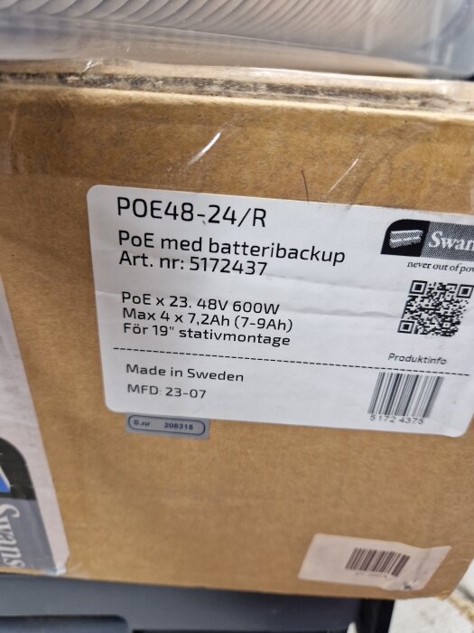 Förpackning med Swanson 24-portars PoE-switch, specificerad för 19" stativmontage och batteribackup, etikett med produktinfo synlig.