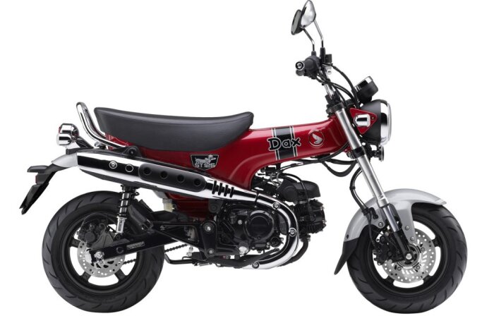 Röd minibike av märket Dax, sedd från sidan, med svart sits och kromdetaljer.