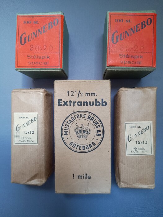 Förpackningar med äldre spik och nubb från Gunnebo och Mustadsfors bruk, Göteborg, märkta med olika storlekar och antal.