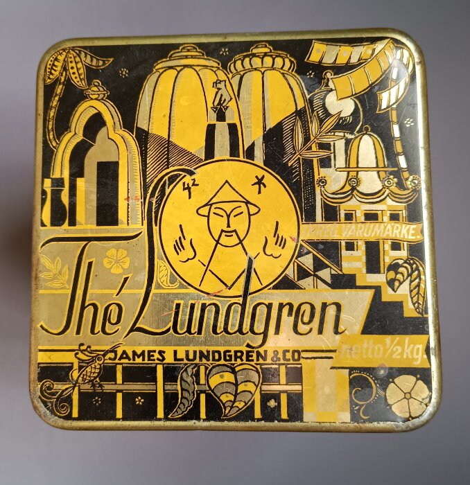 Burk med te från James Lundgren & Co med dekorativa illustrationer i svart och gult.