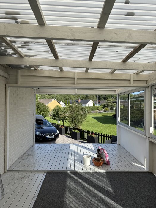 Skjutpartier ut mot trappan, ger mer utrymme inomhus. Syns även trädgård, bil, och förberedd yta för kommande golvmålning.