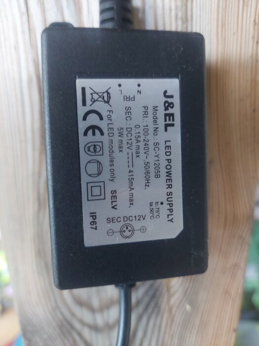 J&EL LED-strömförsörjning med specifikationer för primär och sekundär spänning. Modellnummer SCV-1205B, IP67-klassificerad.