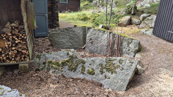 Ved travad i vedbod, stenar och trÀd i bakgrunden.