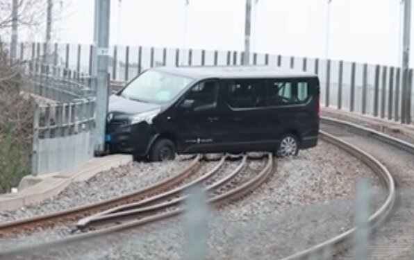 Svart bil körd fast på Tvärbanans spår.