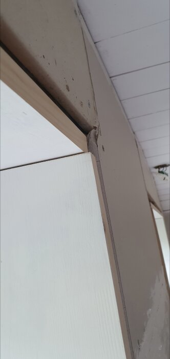 Gipsvägg med fasning ovanför fönster som orsakat felpassning av sidobrädor, synlig kant med feljustering och behov av lösning.