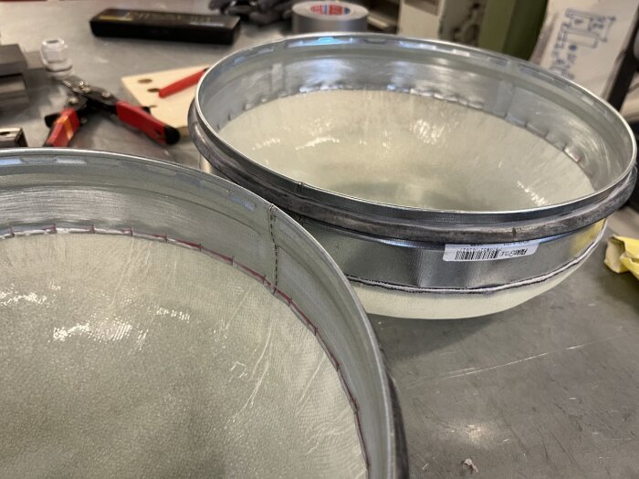 Två cirkulära metalländstycken för en cylinder, del av en batteribox-prototyp byggd för att integreras med ett bastuprojekt.