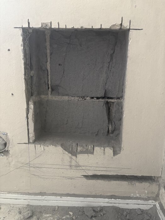 Hål i yttervägg där rör med isolering syns, målade linjer visar antagen rördragning, vägg synligt snett och skadat; diskussion om rörens funktion.