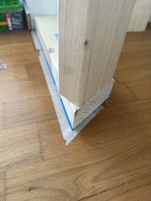 Vertikalregel och bottenregel av trä i närbild, visande snedkantning i vinkel på golv.