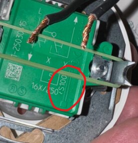 Grön komponent med text om skållängd markerad med rött, kopparledningar syns upptill.