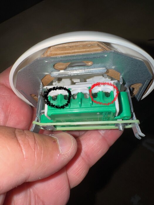 Närbild av en Schneider Renova strömbrytare med två markerade hål, ett svart och ett rött, för inkoppling av L-sladdar.