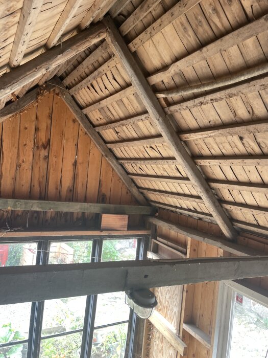 Trätak inomhus med synliga bjälkar i ett gammalt hus från 1920-30-talet i Skåne.
