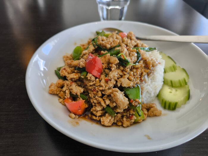 Tallrik med thailändsk kycklingrätt, ris, paprika och gurka på restaurang Thai Sweet Chili i Bromma.