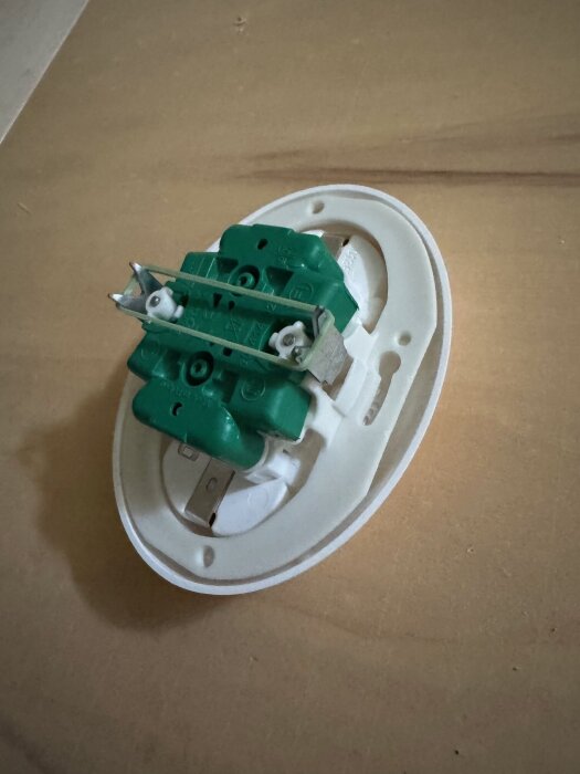 Eluttag Schneider Renova på träyta, bakdelen visas med gröna och vita delar.