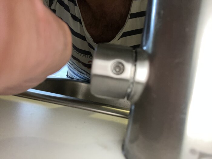 Närbild på en metallvattenavstängare till Älmaren blandare från IKEA, visar ett litet hål på baksidan av reglaget.