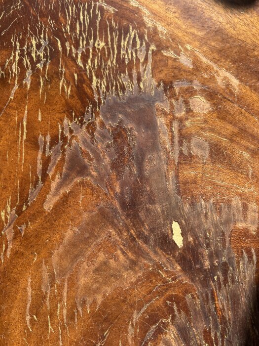 Krackelerad lackyta på gammalt träbord med några små skador i faneret.