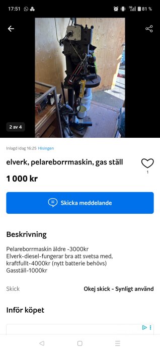 Äldre pelarborrmaskin i ett verkstadsutrymme, med flera verktyg hängandes på maskinen och trävägg i bakgrunden.
