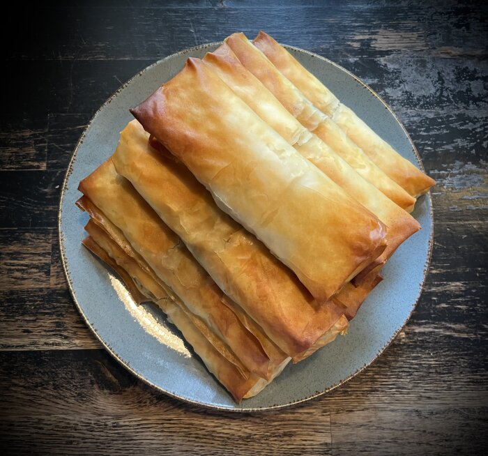 Hemlagade vårrullar på en tallrik, gjorda av filodeg, serverade med ris och sweetchilisås.