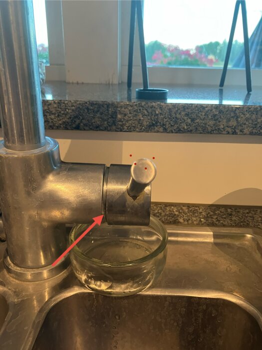 Köksblandare Tapwell EVO186 Krom som läcker vatten i avstängt läge, med glas under pipen för att fånga dropparna.